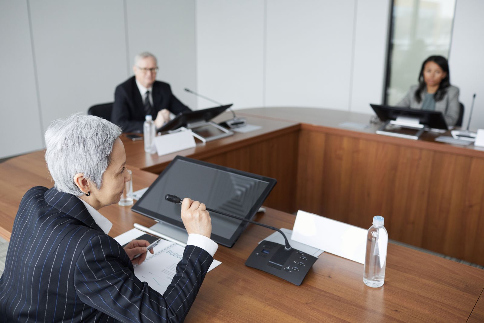 Board-style conference table with fund managers reviewing budget documents, representative of The CEO Fund investment committee