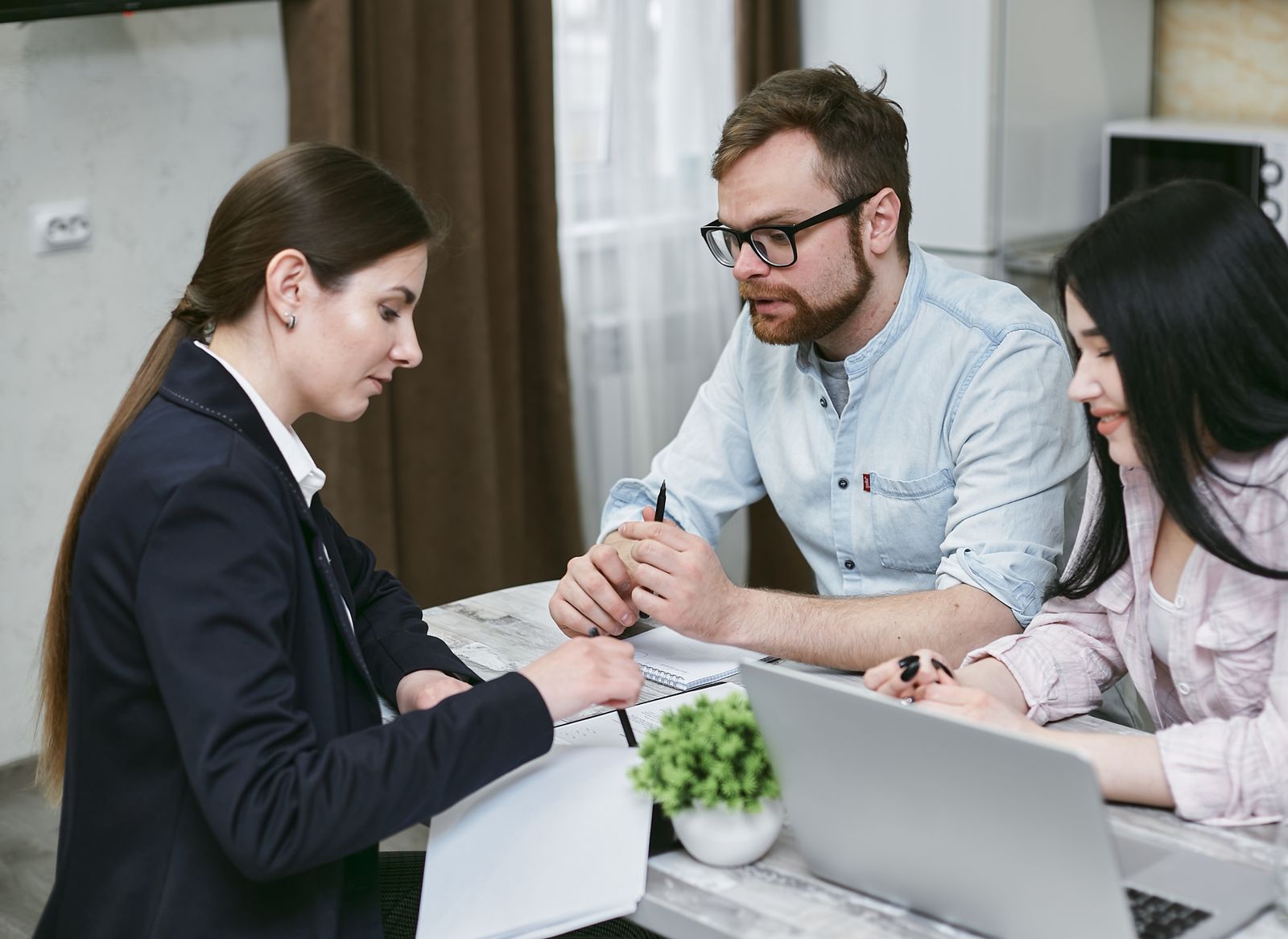 A fund representative walking prospective investors through mortgage note documents at a kitchen table
