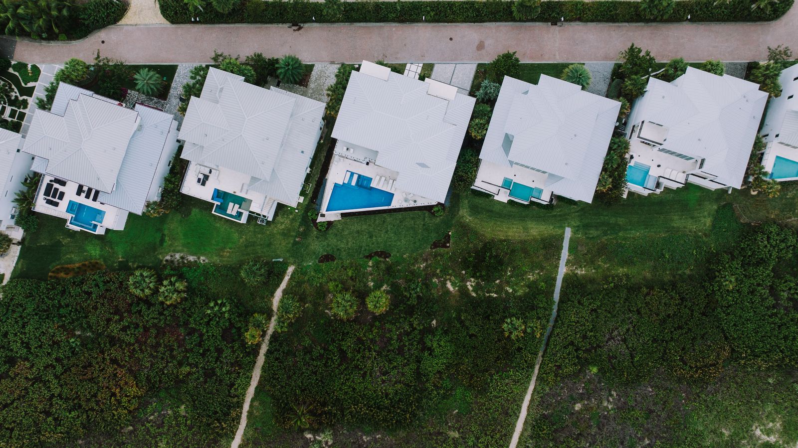 Aerial view of a Florida coastal residential block with completed homes next to undeveloped scrub land, representative of the entitlement transition