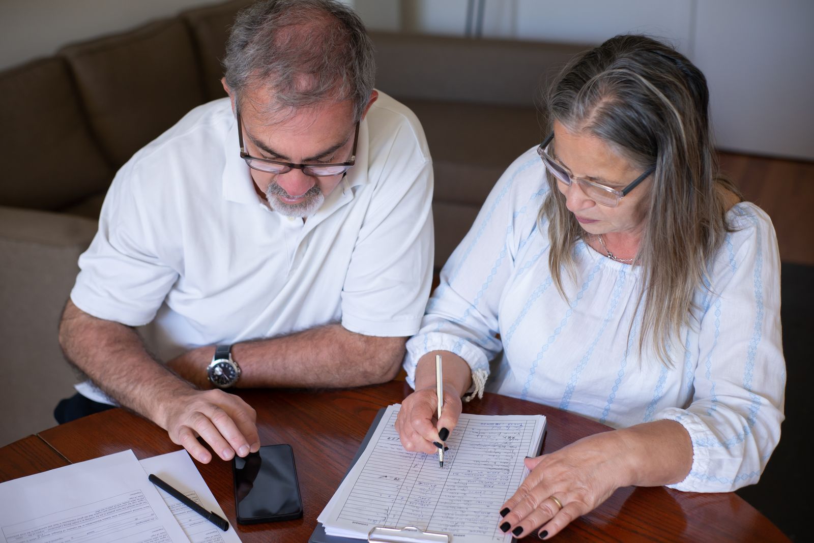 Mature couple at a home table reviewing retirement account paperwork together