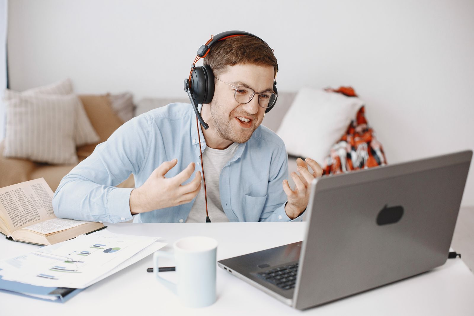 Presenter speaking on a live webinar with a laptop and headset in a home office setting