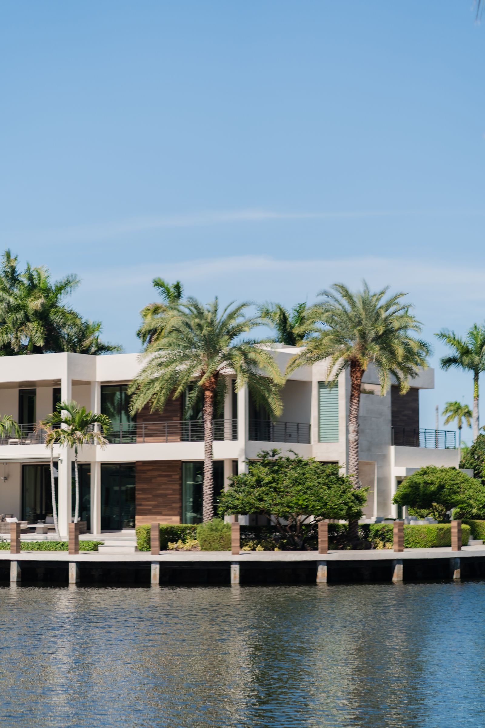 Waterfront Florida villa with palm trees, representative of high net worth real estate exposure
